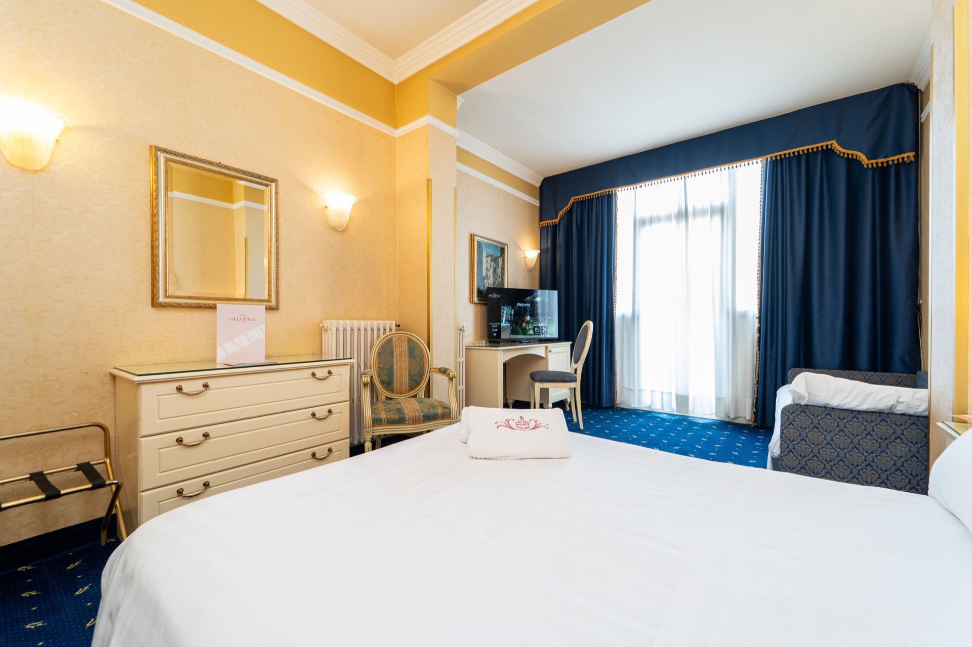 camera tripla con divano letto e dresser