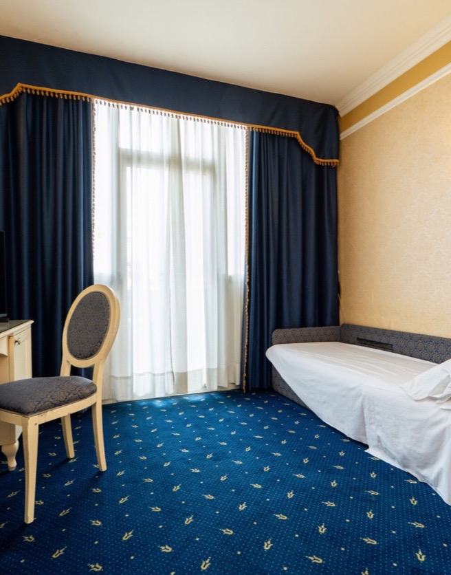 camera tripla con divano letto e tv