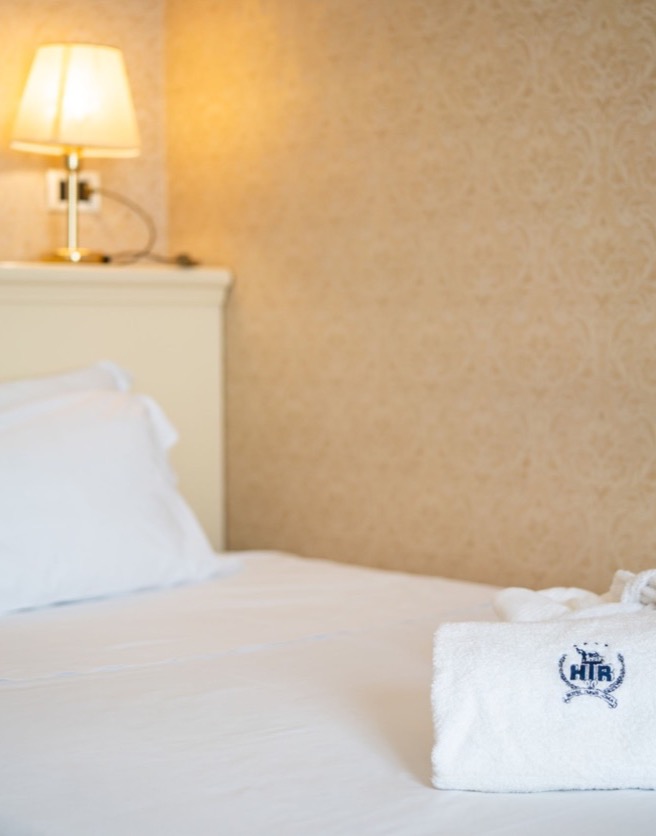 letto singolo con asciugamano e lampada