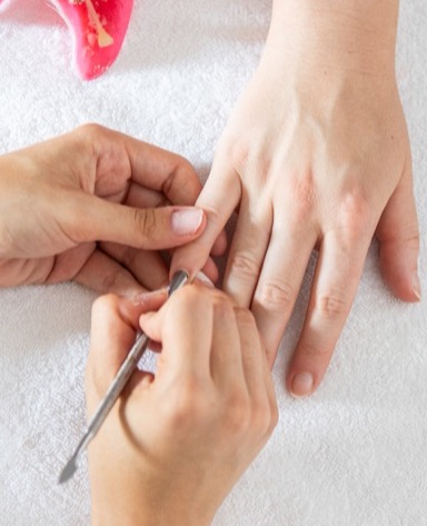 Mani su un asciugamano, una mano riceve una manicure con strumenti per la cura delle unghie.